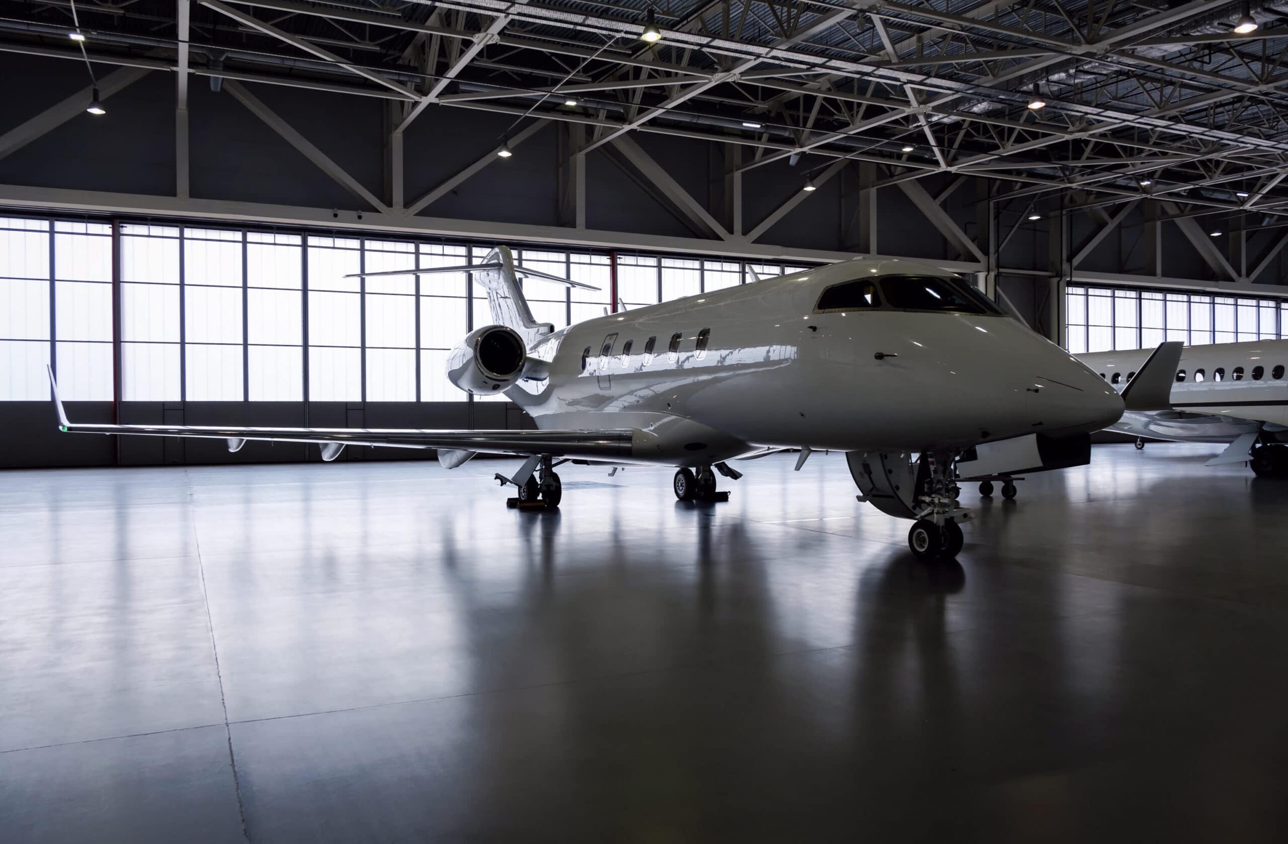 A private jet inside of a hanger, awaiting repairs.
